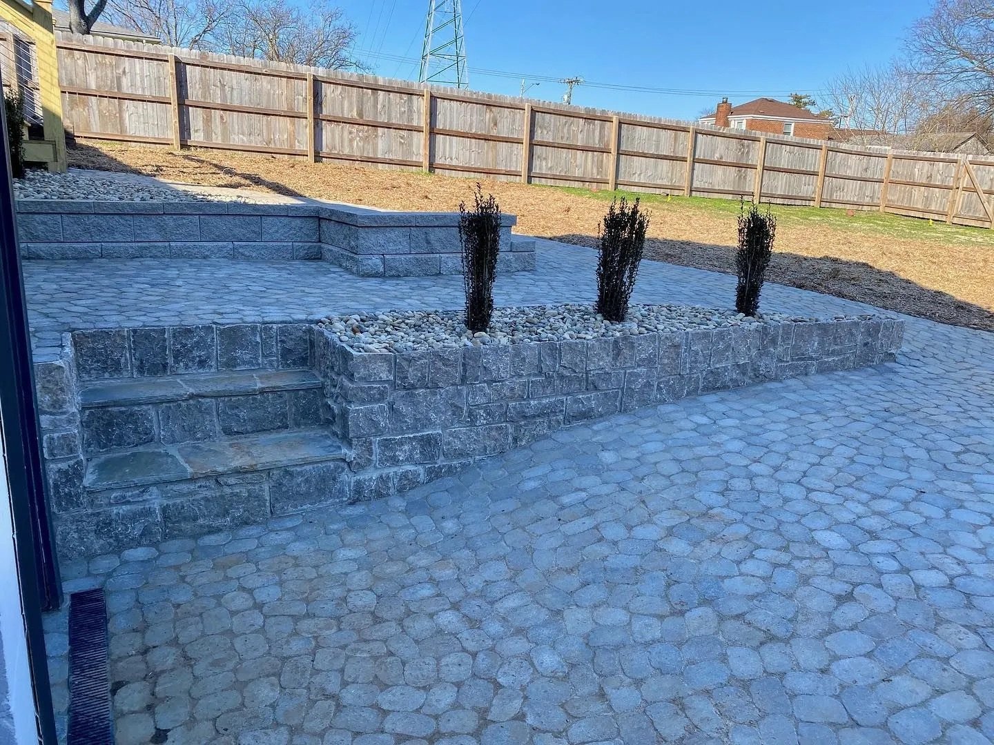 Stone patio with retaining wall and gravel bed