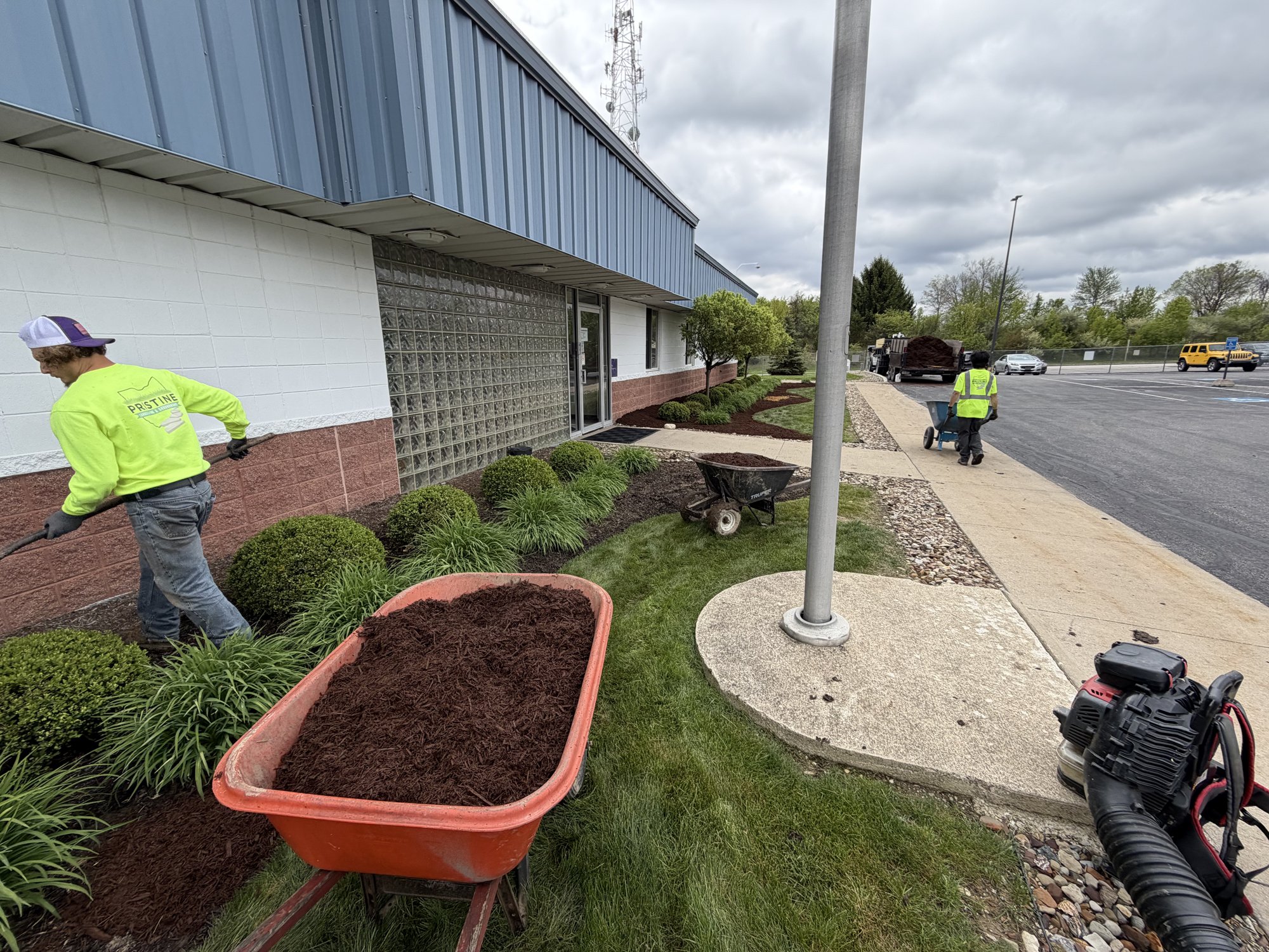 Crew refreshing mulch beds at a commercial office building