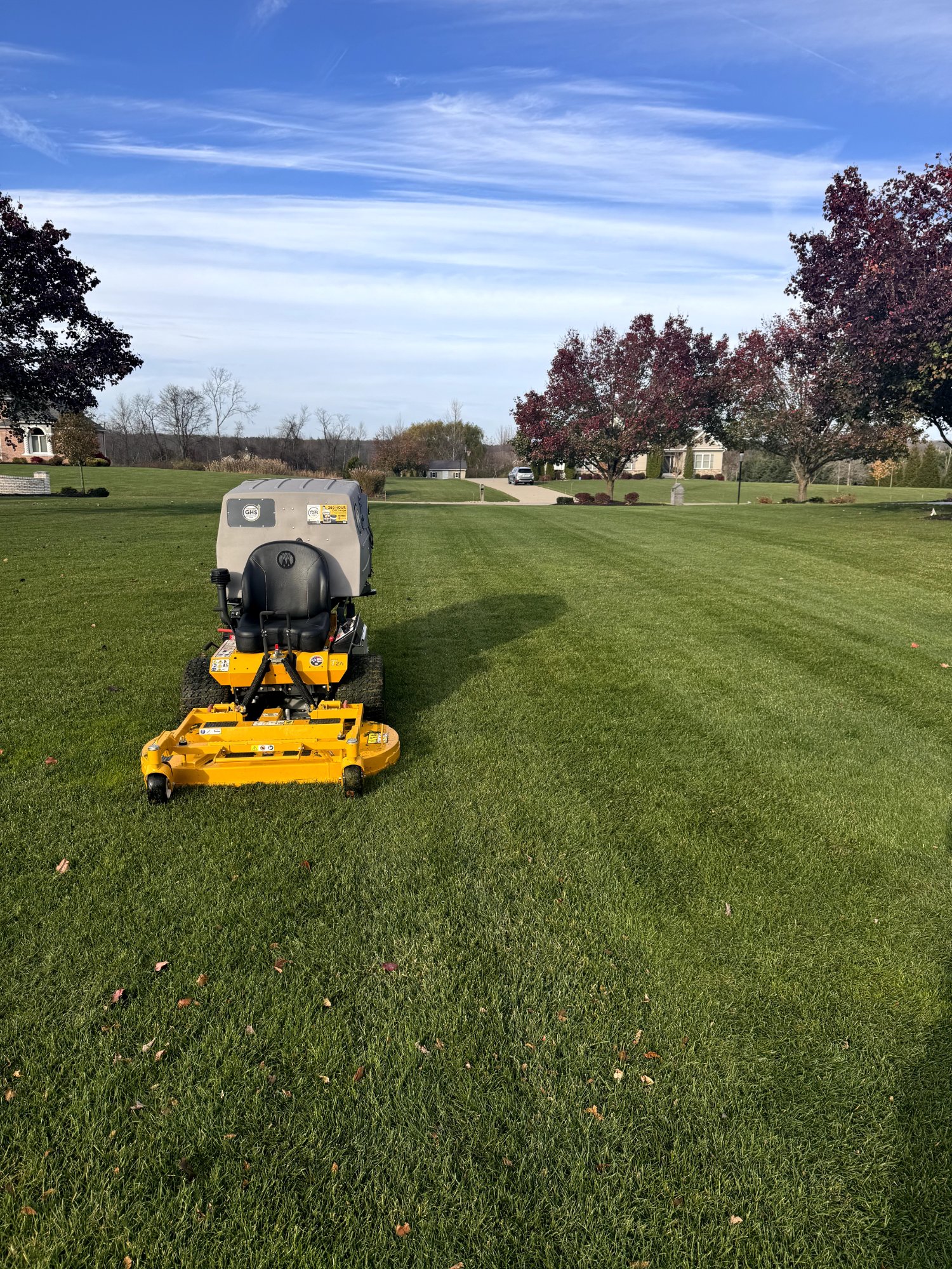 Commercial mower on a neatly striped lawn in autumn